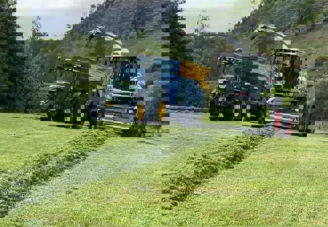 tractor and combine harvester working in a field